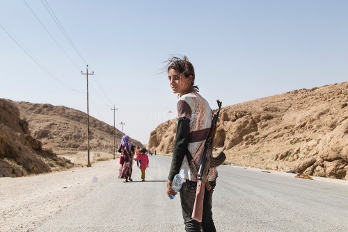 Chica Yezidi con un rifle protegiendo a su famiia contra EI