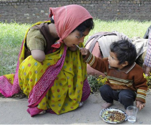 Nino de 2 anos dando de comer a su madre con discapacidad