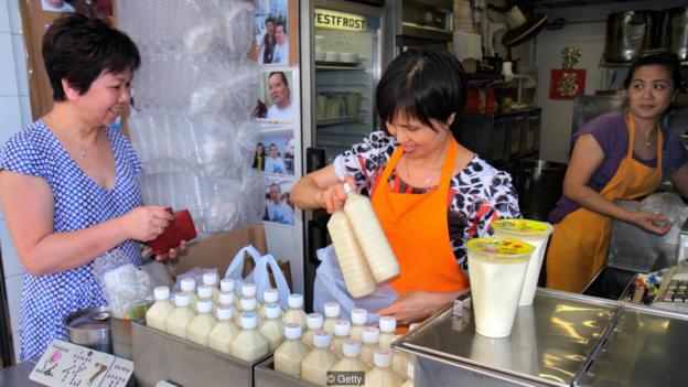 mujer comprando leche soja